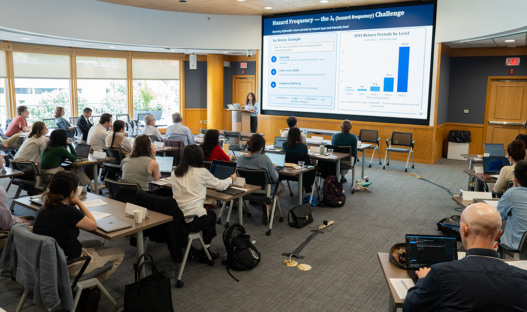 wide image of attendees watching presentation 