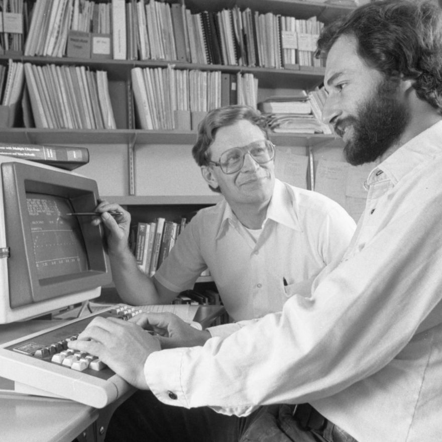 granger with colleague in front of old computer